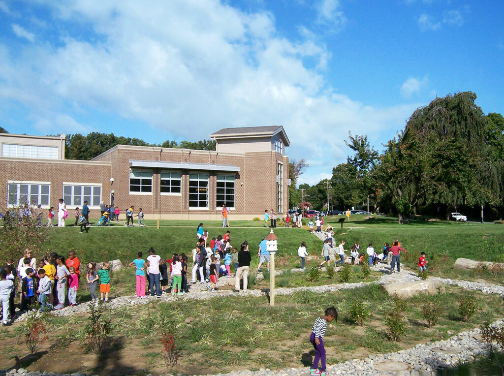 students playing in garden outside elementary school